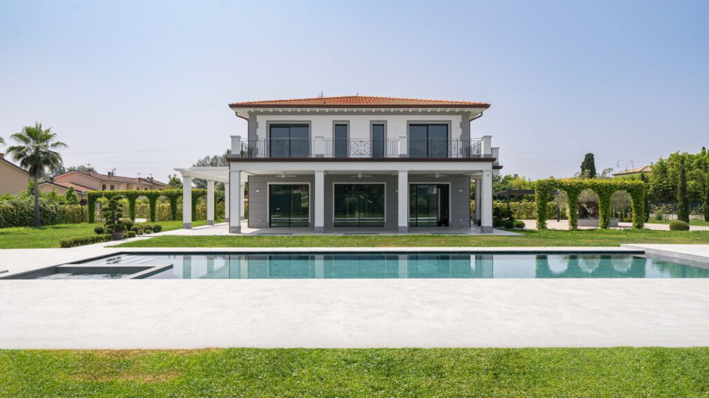 Vendita case Forte dei Marmi: tendenze e desideri degli acquirenti di immobili di prestigio 1 Villa moderna con piscina e giardino curato a Forte dei Marmi, vista frontale della facciata principale con ampie vetrate e terrazza.