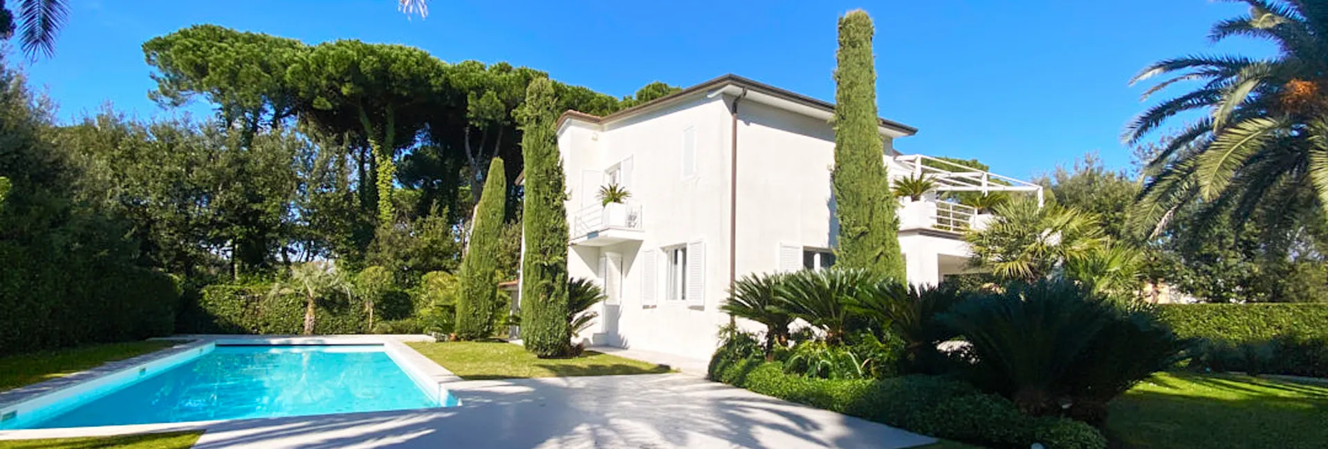 Villa a Roma Imperiale con piscina e giardino curato, esempio di residenza di lusso immersa nel verde di Forte dei Marmi, ideale per chi cerca eleganza e tranquillità in Versilia.