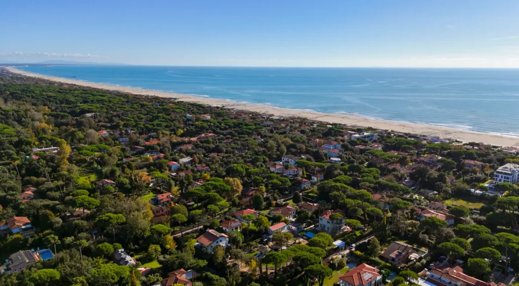 Versilia esclusiva: perché investire in una villa a Roma Imperiale, cuore elegante di Forte dei Marmi 1 Veduta aerea della Riviera della Versilia con spiagge sabbiose, mare azzurro e pinete che circondano le ville di Forte dei Marmi, località esclusiva della costa toscana.