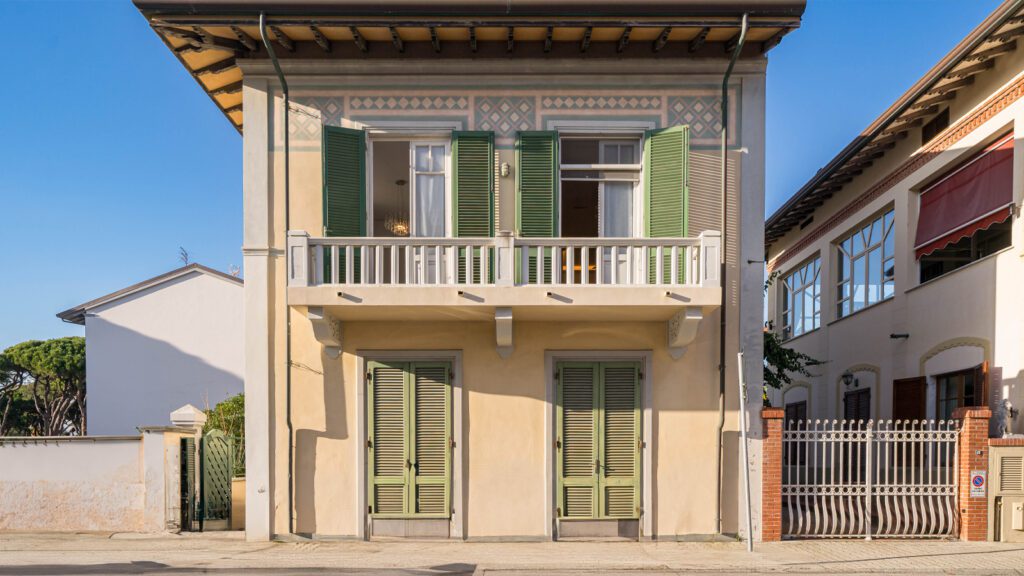 Villa in Versilia nel centro di Forte dei Marmi, elegante residenza storica con balcone, persiane verdi e dettagli architettonici tipici delle ville della costa toscana.