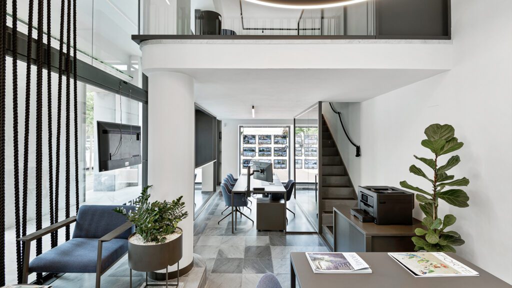 Interno dell’agenzia The Dream Real Estate a Forte dei Marmi, ambiente elegante con postazioni di lavoro e area ricevimento clienti