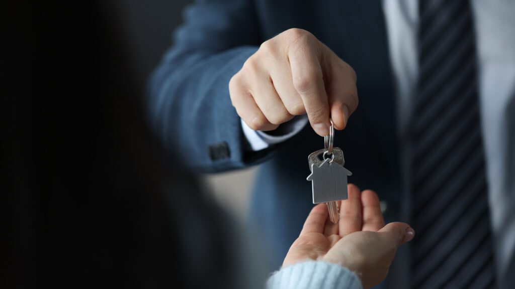 Agente immobiliare che consegna le chiavi di una casa al nuovo proprietario